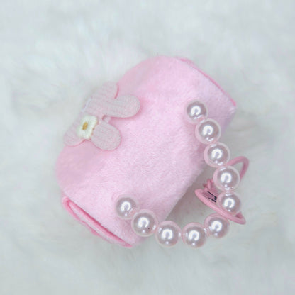 Pink pet accessory with pearl details on a light gray background